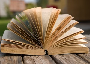 The book is laying on a old wooden table